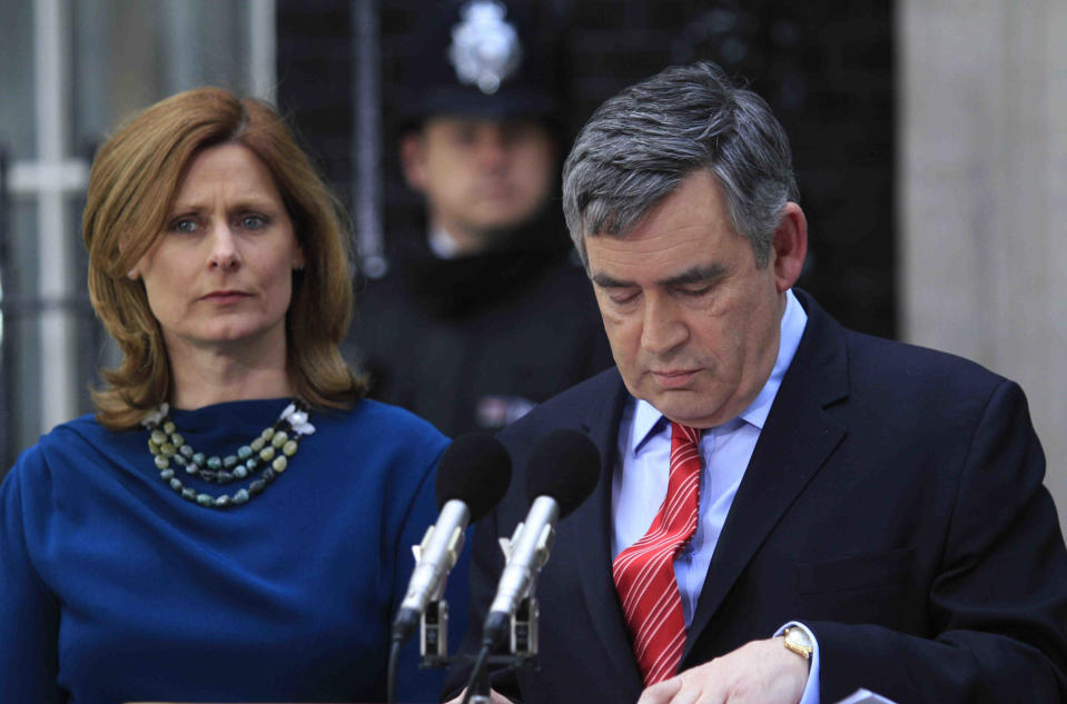 FILE - Britain's Prime Minister Gordon Brown, right, accompanied by wife Sarah, left, announces his resignation as he leaves his official residence at 10 Downing Street in central London, May 11, 2010. When Brown called the general election for May 2010, Labour, which had been in power for 13 years, its longest stretch in government, did better than expected and denied the Conservative Party, now led by the smooth David Cameron, a majority in the House of Commons. (AP Photo/Lefteris Pitarakis, File)