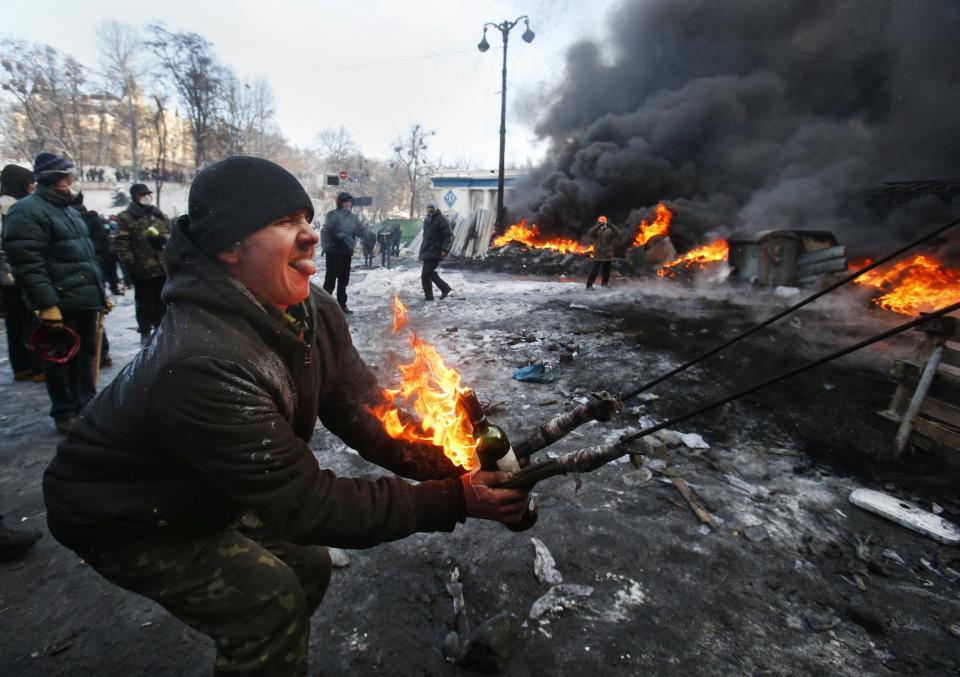 FILE - In this file photo taken on Thursday, Jan. 23, 2014, Protesters use a large slingshot to hurl a Molotov cocktail at police in central Kiev, Ukraine. Protesters in Kiev built the catapult to pelt firebombs at police at a longer distance and bigger damage. Thick black smoke from burning tires engulfed parts of downtown Kiev as an ultimatum issued by the opposition to the president to call early election or face street rage was set to expire with no sign of a compromise on Thursday. (AP Photo/Sergei Grits, file)