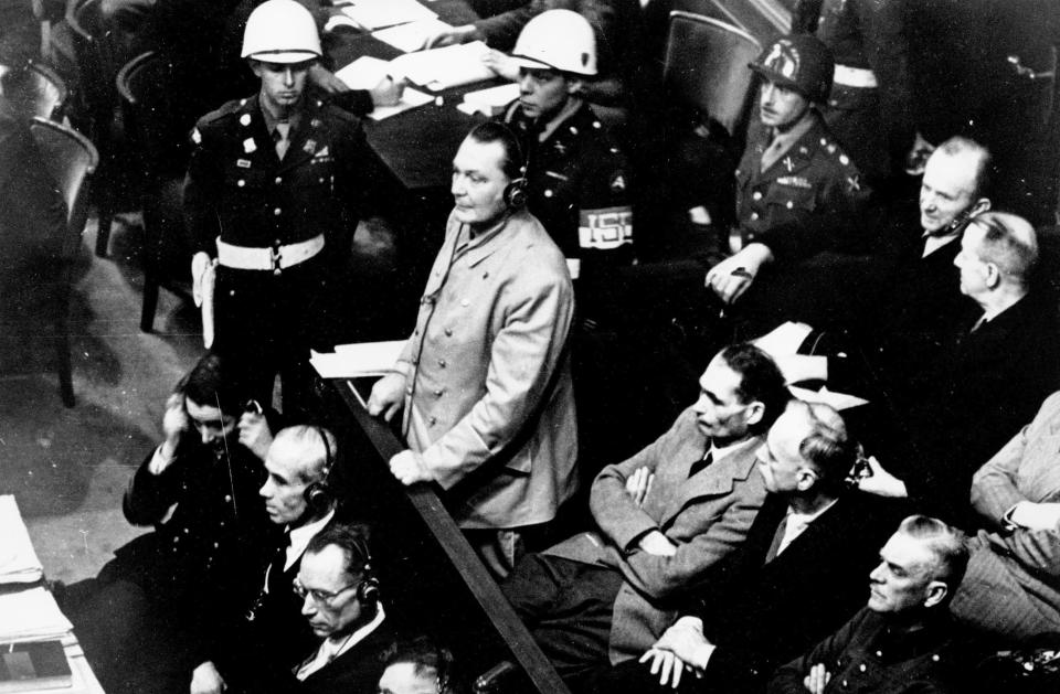 FILE - In this Nov. 21, 1945 file photo, Reichsmarshal Hermann Goering stands in the prisoner's dock at the Nuremberg War Crimes Trial in Germany. He is entering a plea of not guilty to the International Military Tribunal Indictment. Goering is wearing headphones of the court translating system. Germany marks the 75th anniversary of the landmark Nuremberg trials of several Nazi leaders and in what is now seen as the birthplace of a new era of international law on Friday, Nov. 20, 2020. (AP Photo, file)