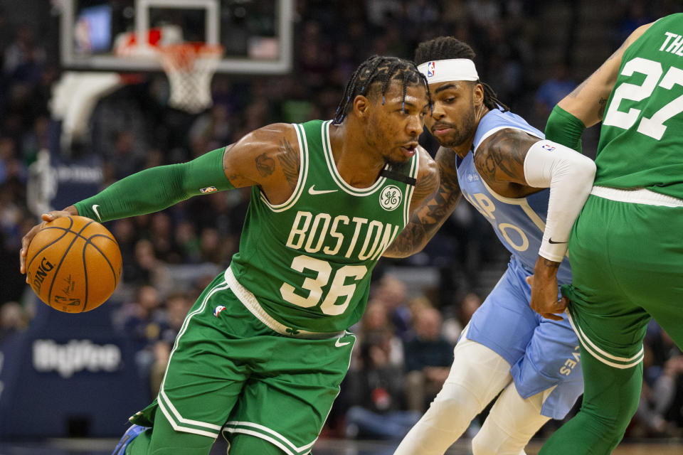 Boston Celtics guard Marcus Smart (36) drives on Minnesota Timberwolves guard D'Angelo Russell (0) in the second quarter of an NBA basketball game Friday, Feb. 21, 2020, in Minneapolis. (AP Photo/Andy Clayton-King)