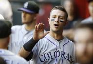 Colorado Rockies' Troy Tulowitzki walks throughout the dugout giving out high-fives prior to a baseball game against the Arizona Diamondbacks on Tuesday, April 29, 2014, in Phoenix. (AP Photo/Ross D. Franklin)