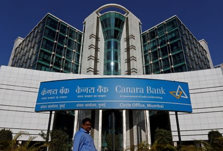 FILE PHOTO: A man walks past a Canara Bank office in Mumbai