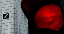 FILE PHOTO: A red traffic lights is seen next to the headquarters of Germany's Deutsche Bank in Frankfurt