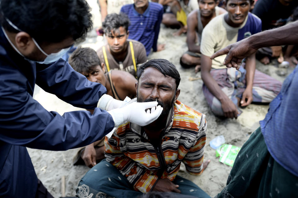 A paramedic performs a nasal swab test to an ethnic Rohingya man after he and his group landed in Pidie, Aceh province, Indonesia, Sunday, Dec. 10, 2023. Two boats carrying hundreds of Rohingya Muslims, including women and children, arrived at Indonesia's northernmost province of Aceh on Sunday morning after being adrift for weeks. (AP Photo/Reza Saifullah)