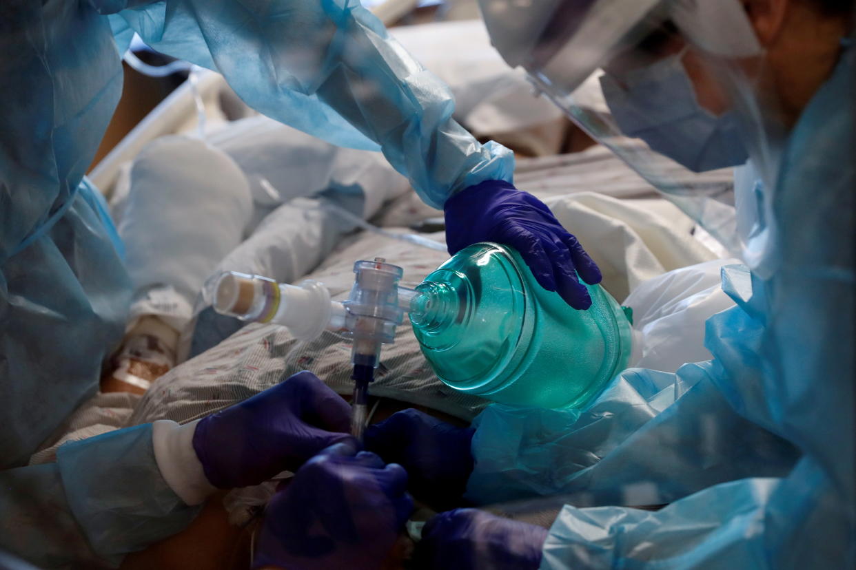 Critical care workers insert an endotracheal tube into a COVID-19 patient in the ICU at Sarasota Memorial Hospital in Sarasota, Fla., in February.