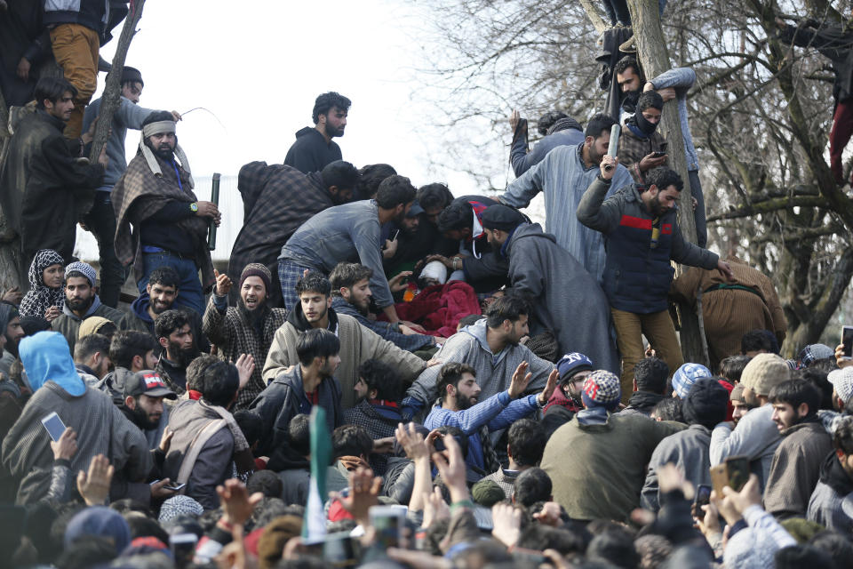 Kashmiri villagers assemble near the body of rebel commander Zeenatul Islam during his funeral procession in Sugan village 61 kilometers (38 miles) south of Srinagar, Indian controlled Kashmir, Sunday, Jan. 13, 2019. Massive anti-India protests and clashes erupted in disputed Kashmir on Sunday, leading to injuries to at least 16 people after a gunbattle between militants and government forces overnight killed two rebels, police and residents said. (AP Photo/Mukhtar Khan)