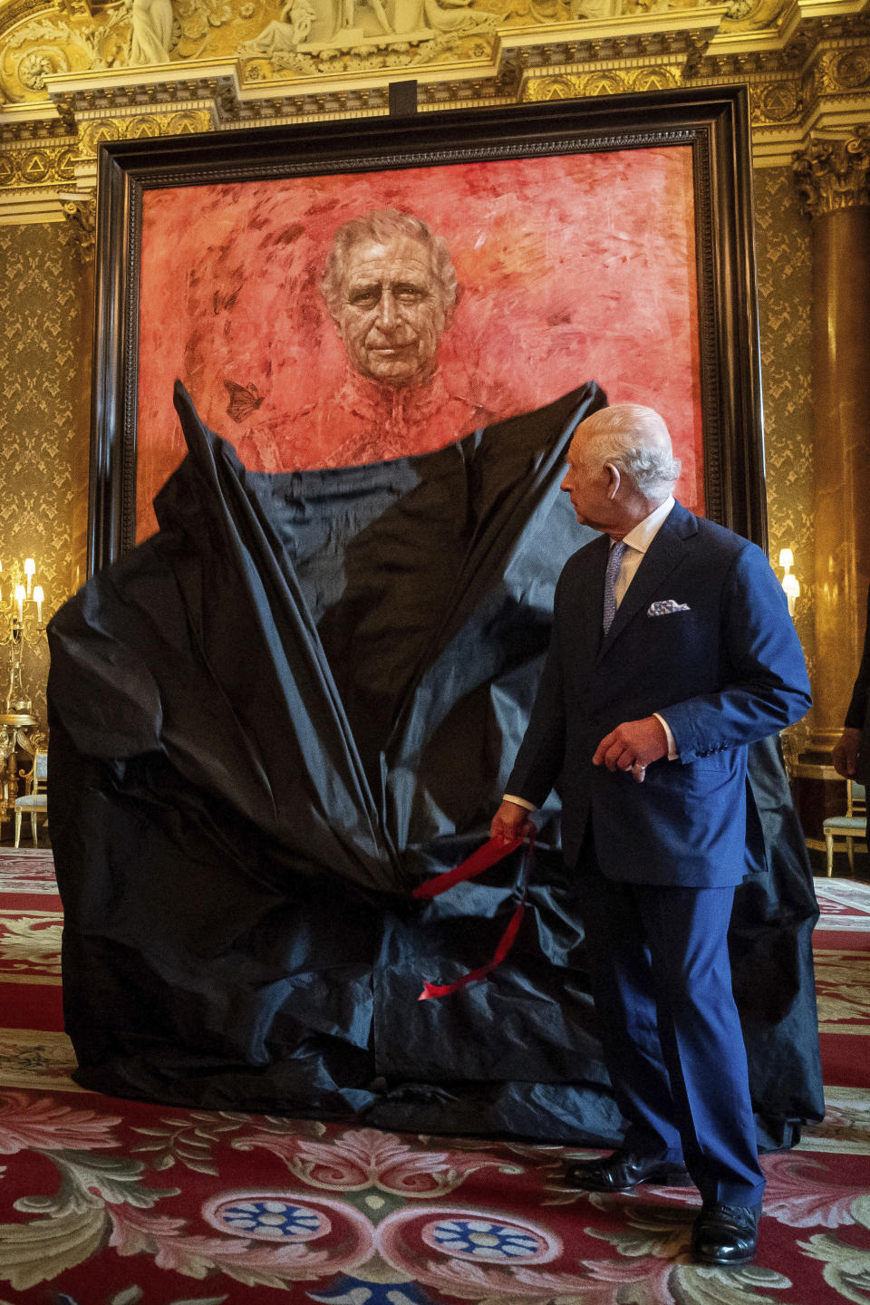 Britain's King Charles III unveils artist Jonathan Yeo's portrait of the King, in the blue drawing room at Buckingham Palace, in London, Tuesday May 14, 2024. The portrait was commissioned in 2020 to celebrate the then Prince of Wales's 50 years as a member of The Drapers' Company in 2022. The artwork depicts the King wearing the uniform of the Welsh Guards, of which he was made Regimental Colonel in 1975. The canvas size - approximately 8.5 by 6.5 feet when framed - was carefully considered to fit within the architecture of Drapers' Hall and the context of the paintings it will eventually hang alongside. (Aaron Chown/Pool Photo via AP)