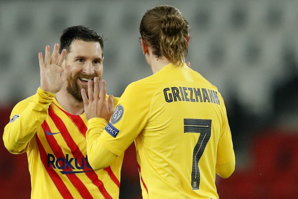 Barcelona's Lionel Messi, left, celebrates after scoring his side's opening goal with Barcelona's Antoine Griezmann during the Champions League, round of 16, second leg soccer match between Paris Saint-Germain and FC Barcelona at the Parc des Princes stadium in Paris, Wednesday, March 10, 2021. (AP Photo/Christophe Ena)