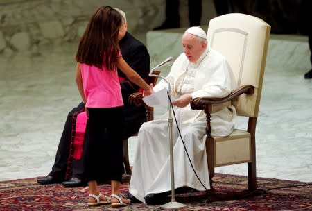 Pope Francis allows a little girl suffering from an undisclosed illness to move around undisturbed clapping and dancing on the stage for most of his general audience in Paul VI Hall at the Vatican