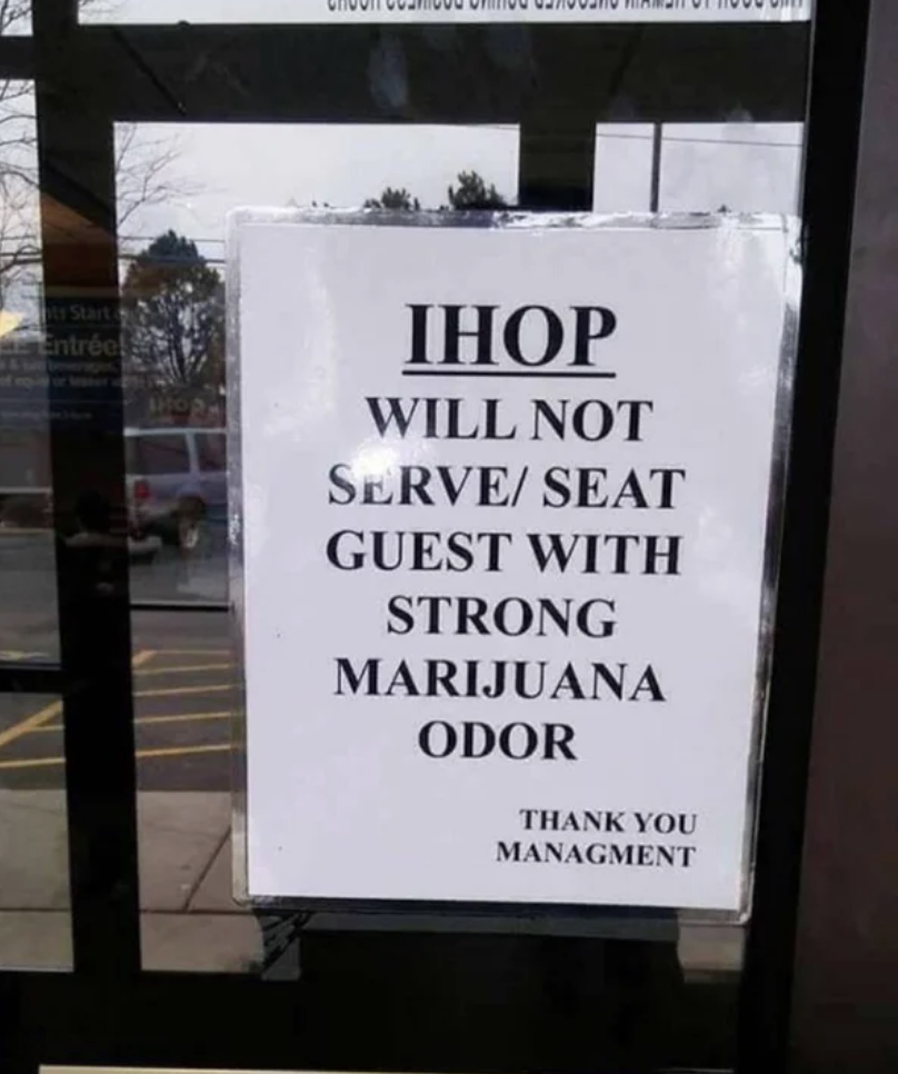 A sign on the door to an IHOP says "will not serve or seat guest with strong marijuana odor"