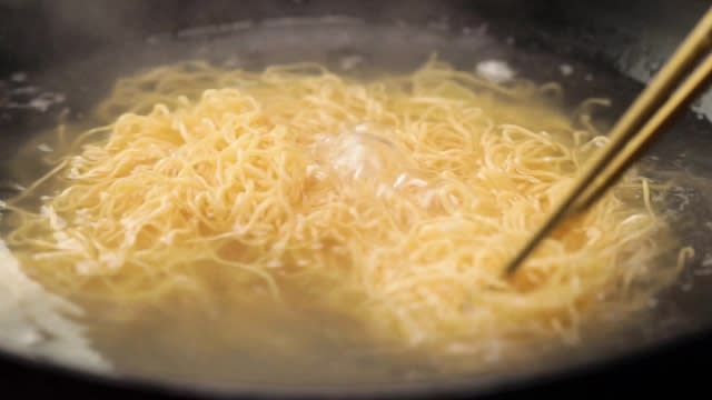 Stirring noodles with chopsticks