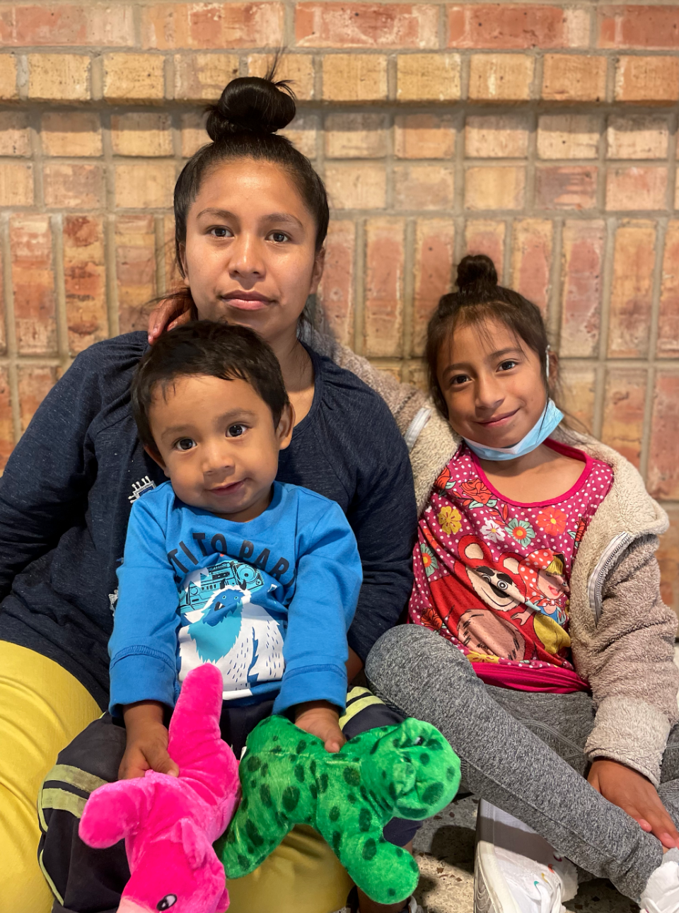 Jacqueline and her two children sit at a bus station in Brownsville, Texas waiting for the bus that would them to North Carolina. She will be staying with relatives until a judge makes a decision in her family's asylum case. / Credit: Natacha Larnaud