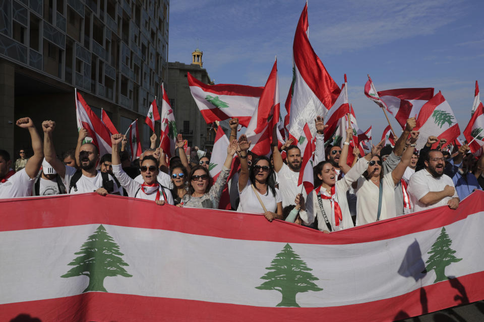 Anti-government protesters shout slogans during separate civil parade at the Martyr square, in downtown Beirut, Lebanon, Friday, Nov. 22, 2019. Protesters gathered for alternative independence celebrations, converging by early afternoon on Martyrs’ Square in central Beirut, which used to be the traditional location of the official parade. Protesters have occupied the area, closing it off to traffic since mid-October. (AP Photo/Hassan Ammar)