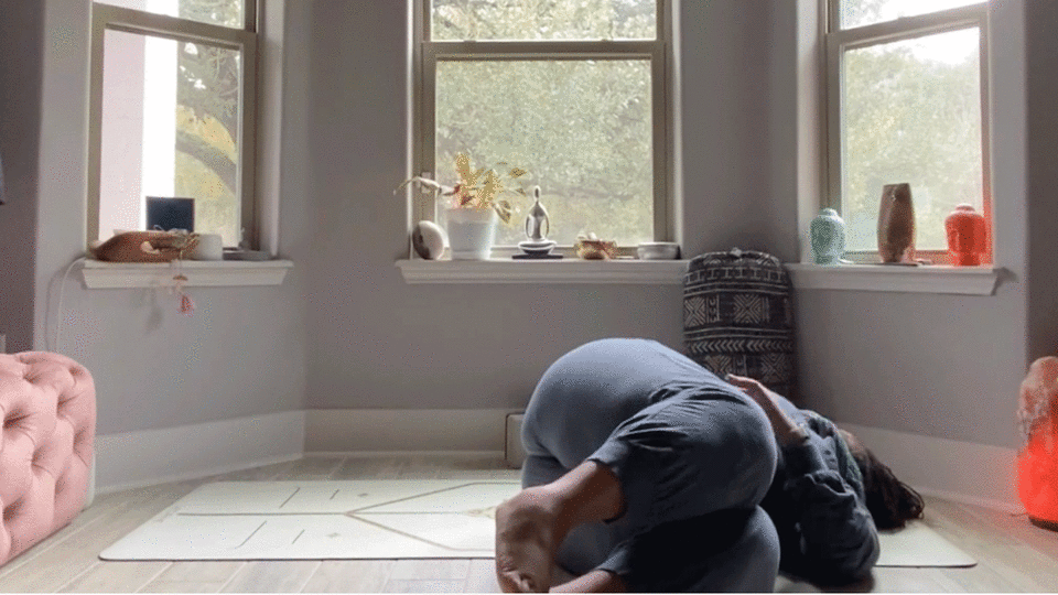 Woman doing a simple twist to stretch her low back while lying on the floor in her bedroom