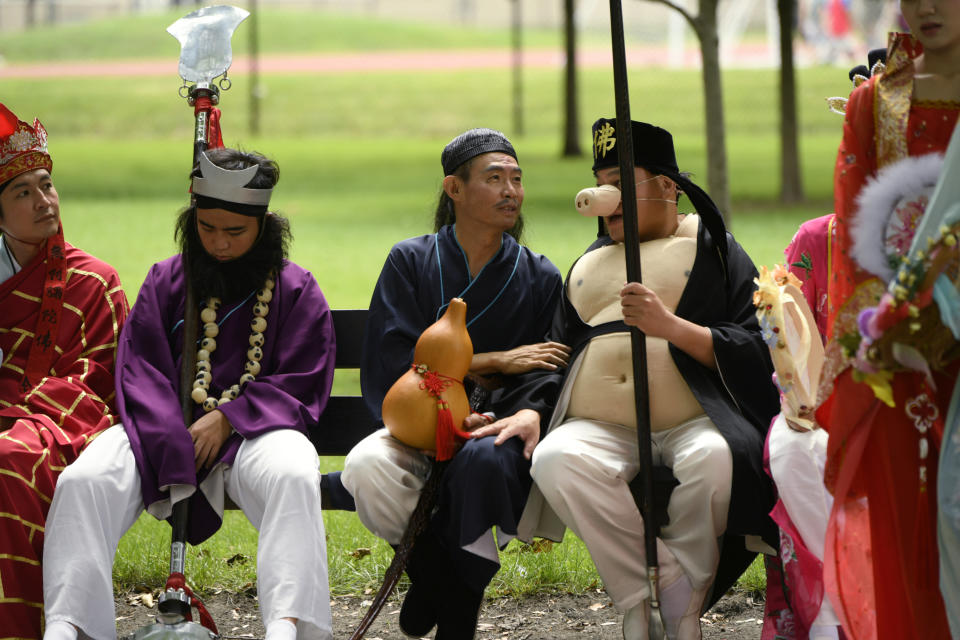 Members of the Tai Ji Men Qigong Academy talk before the Parliament of World Religion Parade of Faiths, Sunday, Aug. 13, 2023, in Chicago. (AP Photo/Paul Beaty)