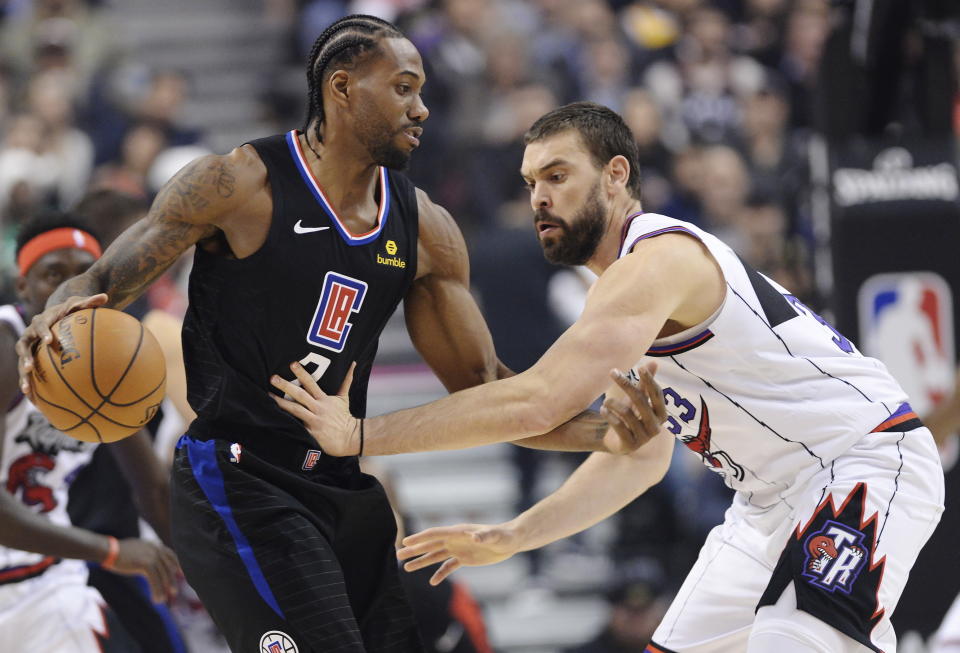 Kawhi Leonard de los Clippers de Los Ángeles protege el baón de Marc Gasol en el juego del 11 de diciembre del 2019 en Toronto. (Nathan Denette/The Canadian Press via AP)