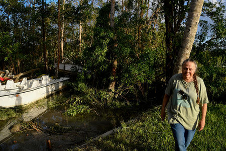 Brenda Hamilton, 62, walks away after seeing her business's boats resting in the trees following Hurricane Irma in Everglades City, Florida, U.S., September 11, 2017. REUTERS/Bryan Woolston