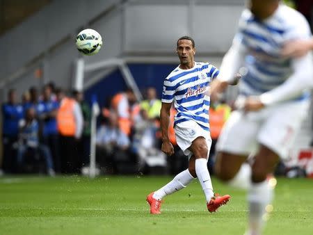 Queens Park Rangers' Rio Ferdinand plays the ball up the pitch during their English Premier League soccer match against Hull City at Loftus Road in London August 16, 2014. REUTERS/Dylan Martinez