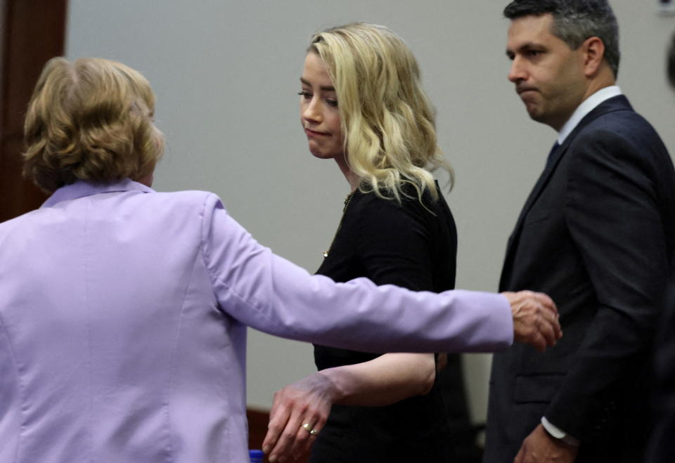 Actor Amber Heard reacts next to her lawyer Elaine Bredehoft after the jury said that they believe she defamed ex-husband Johnny Depp while announcing split verdicts in favor of both her ex-husband Johnny Depp and Heard on their claim and counter-claim in the Depp v. Heard civil defamation trial at the Fairfax County Circuit Courthouse in Fairfax, Virginia, U.S., June 1, 2022. REUTERS/Evelyn Hockstein/Pool