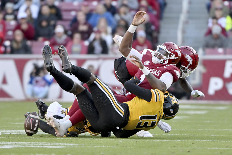 Arkansas quarterback KJ Jefferson (1) fumbles the ball as he is tackled by Missouri defensive back Daylan Carnell (13) during the first half of an NCAA college football game Friday, Nov. 24, 2023, in Fayetteville, Ark. (AP Photo/Michael Woods)