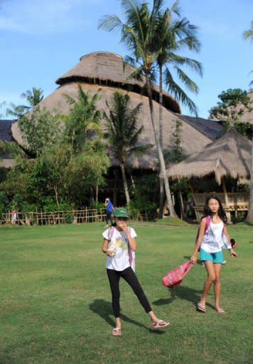 School children stand in front of a building made of bamboo at a school at a village in Sibang, Badung regency on Bali island. The school, which opened in 2008 and was the magnet for other two projects, has 25 bamboo buildings, the main one being a stilt-structure constructed with 2,500 bamboo poles, or culms