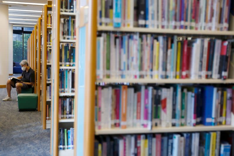 A man reads a book at Hong Kong Central Library after democracy activists' books were taken down due to national security law in Hong Kong