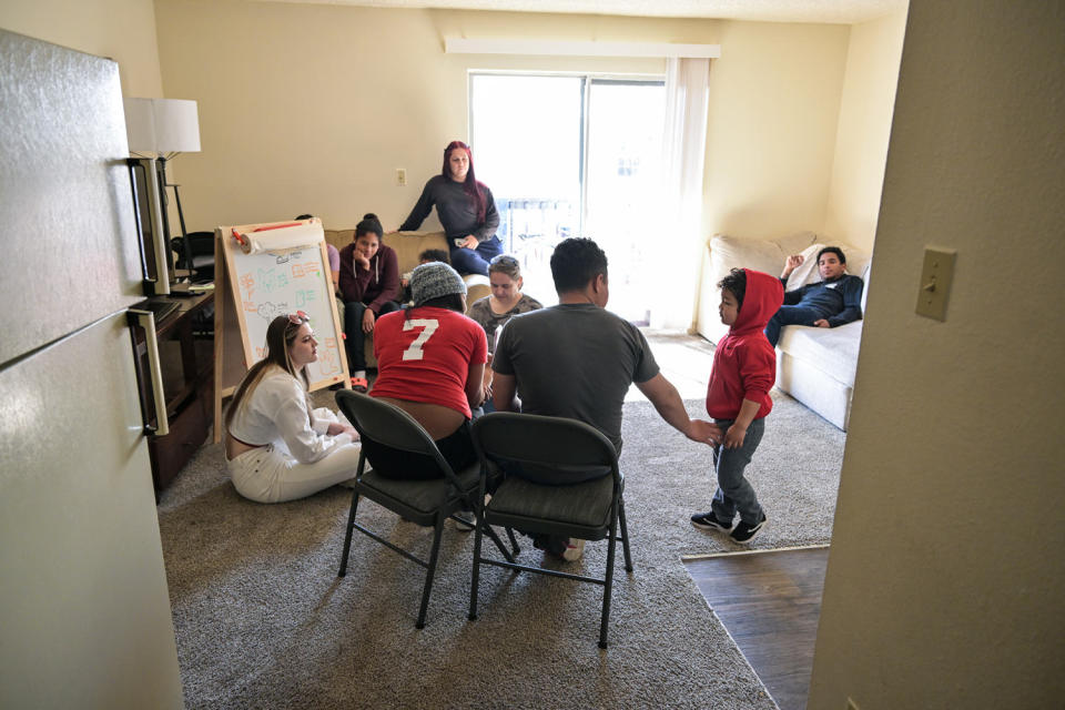 A family of Venezuelan migrants sit inside of their apartment living room (Hyoung Chang / Denver Post via Getty Images file)