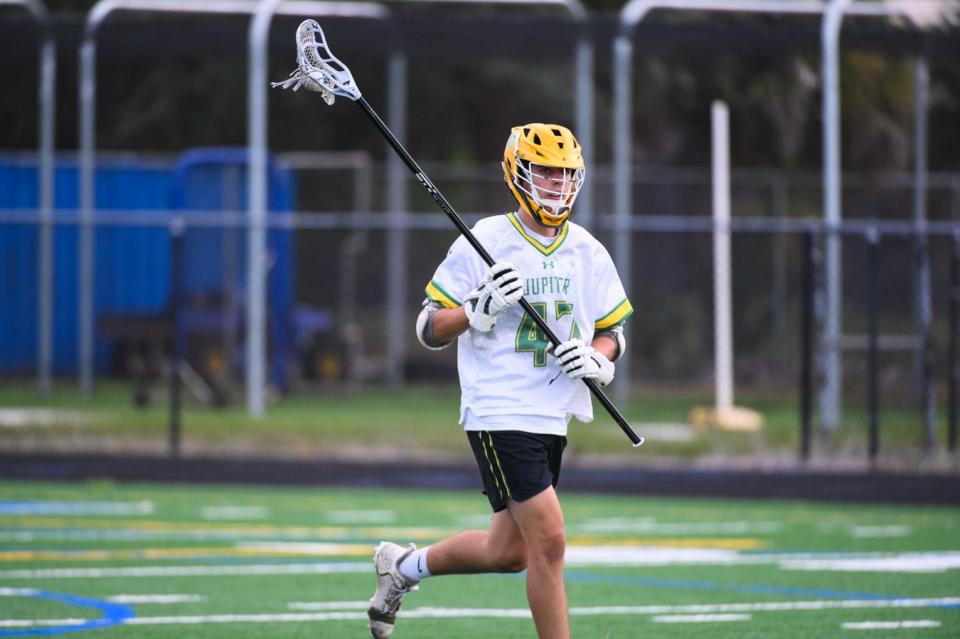 Jupiter defender Alan Druhot (47) moves the ball up the field in the first half during the Class 2A Lacrosse District 13 Championship game between Jupiter and host Welington in Wellington, FL., on Thursday, April 14, 2022. Final score, Jupiter 15, Wellington, 3.