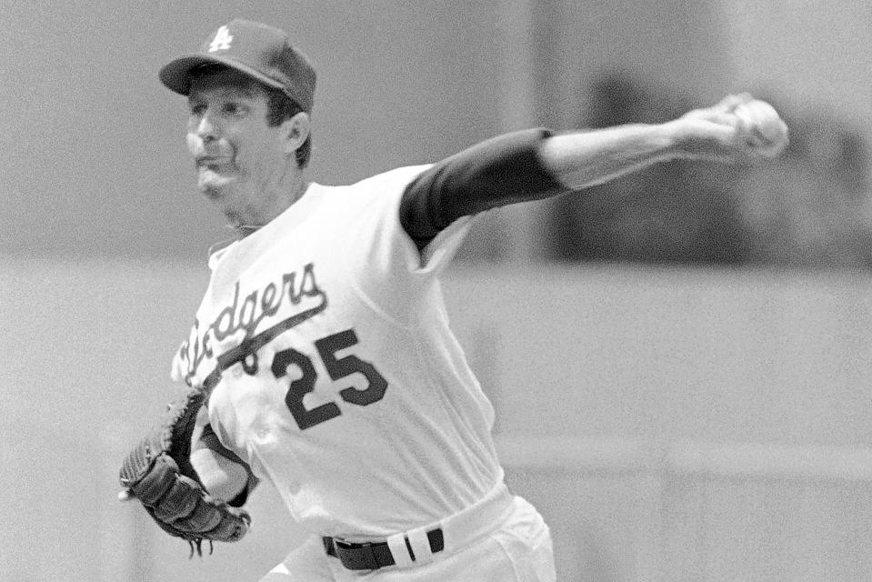 FILE - Los Angeles Dodgers left-hander Tommy John delivers a pitch against Atlanta Braves during an opening day baseball game at Dodgers Stadium in Los Angeles, April 14, 1978. Almost 50 years ago, on Sept. 25, 1974, Dr. Frank Jobe reconstructed a torn ulnar collateral ligament in John's left arm. It was a pioneering achievement for Jobe and a lifeline for John, who went from a career-ending injury to 14 more years in the majors — and an eponymous connection to sports medicine that would live on long past his playing days. Tommy John surgery.(AP Photo/LM, File)