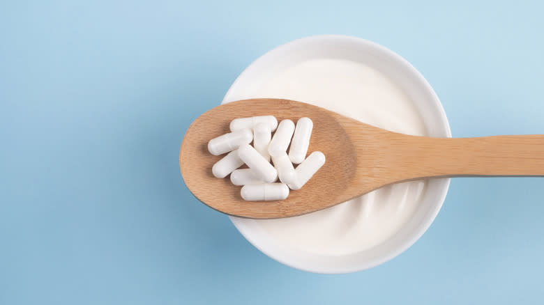 yogurt bowl and spoonful of probiotic capsules