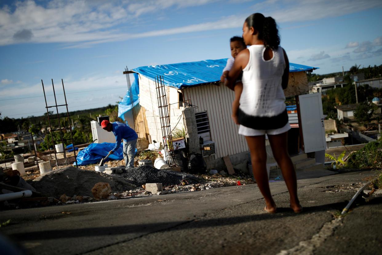 File: Samuel Vasquez rebuilds his house, which was partially destroyed by Hurricane Maria, while his wife Ysamar Figueroa looks on: Reuters