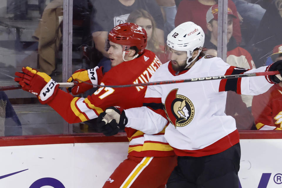 Calgary Flames' Yan Kuznetsov, left, is hit by Ottawa Senators' Mark Kastelic during the second period of an NHL hockey game Tuesday, Jan. 9, 2024, in Calgary, Alberta. (Larry MacDougal/The Canadian Press via AP)