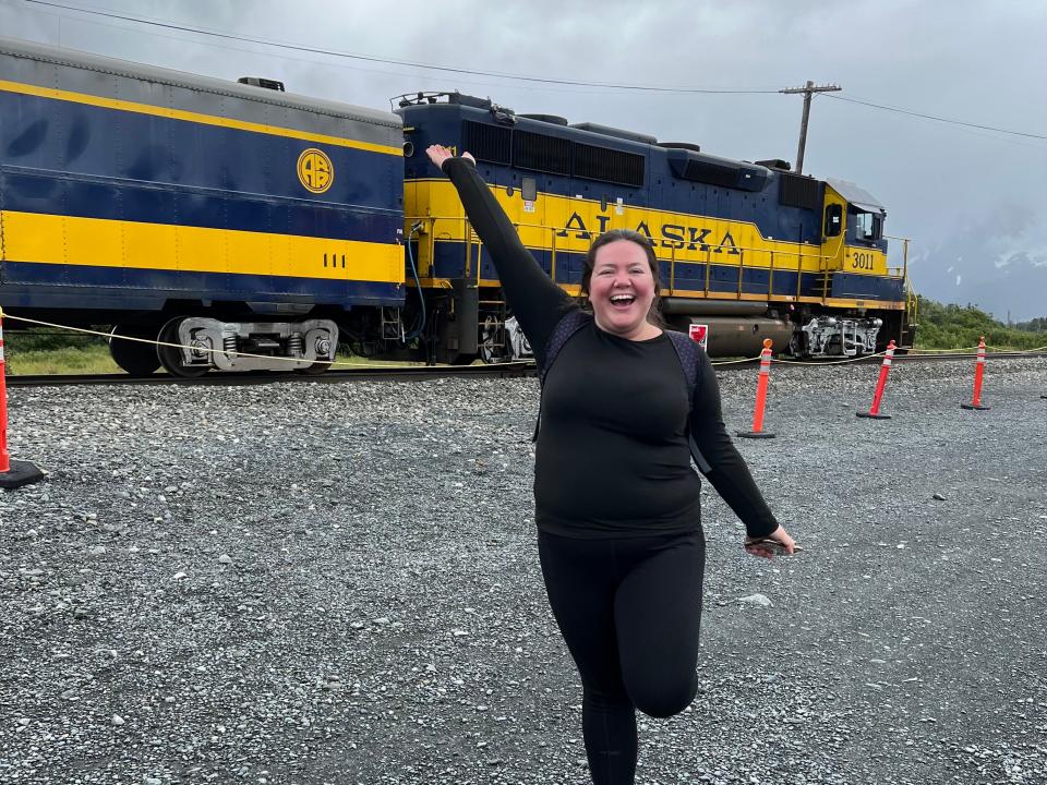 Megan duBois in front of blue and yellow alaska train