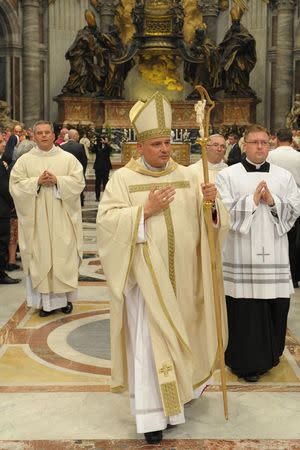 Archbishop Konrad Krajewski blesses faithful during a ceremony in Saint Peter's Basilica at the Vatican September 17, 2013. Picture taken September 17, 2013. Vatican Media/Handout via REUTERS