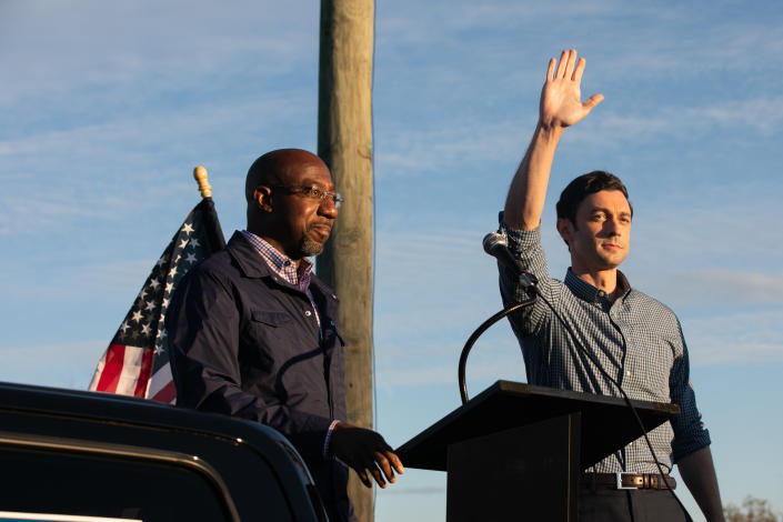 Georgia Democratic U.S. Senate candidates Jon Ossoff (R) and Raphael Warnock (L) wave to supporters during a rally on November 15, 2020 in Marietta, Georgia. (Jessica McGowan/Getty Images)                                          