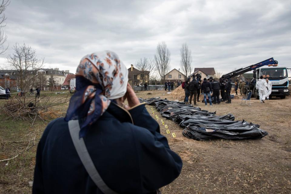 Natalia Lukyanenko watches authorities excavate a mass grave in Bucha, Kyiv region (Anastasia Taylor-Lind)