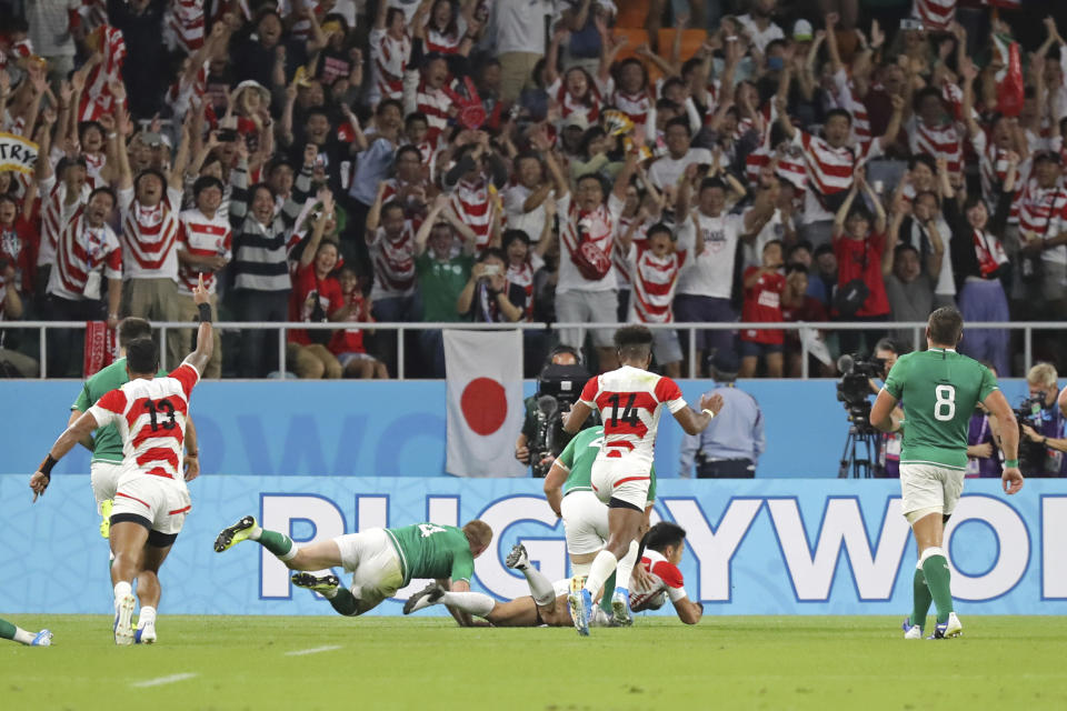 Japan's Kenki Fukuoka, center at bottom, scores a try during the Rugby World Cup Pool A game at Shizuoka Stadium Ecopa between Japan and Ireland in Shizuoka, Japan, Saturday, Sept. 28, 2019. (AP Photo/Eugene Hoshiko)