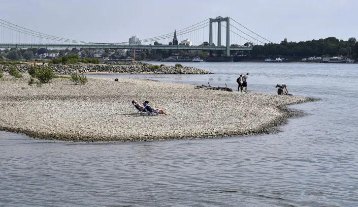 FILE - People enjoy the sunny weather on dry river banks of Germany's most important river Rhine in Cologne, Germany, after a long time of drought, April 27, 2020. The intensity of extreme drought and rainfall has “sharply” increased over the past 20 years, according to a study published Monday, March 13, 2023, in the journal Nature Water. (AP Photo/Martin Meissner, File)