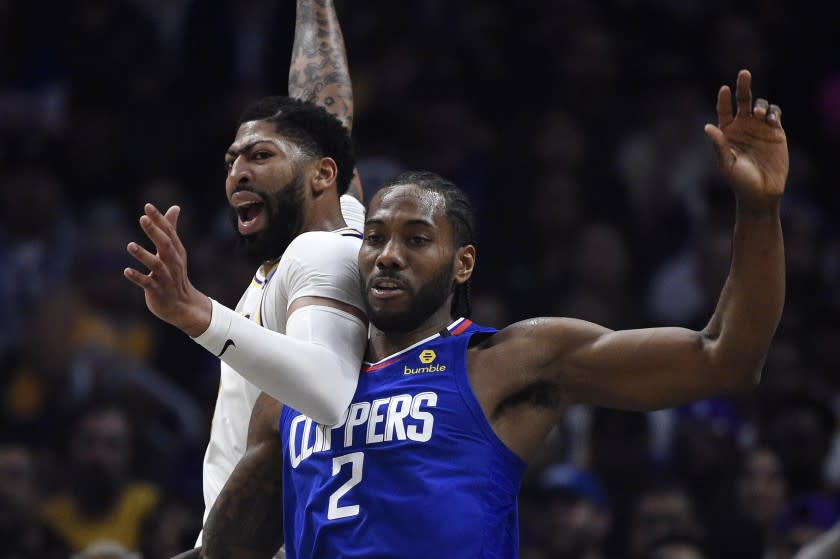 Los Angeles Lakers forward Anthony Davis, left, and Los Angeles Clippers guard Kawhi Leonard battle for position during the first half of an NBA basketball game Sunday, March 8, 2020, in Los Angeles. (AP Photo/Mark J. Terrill)