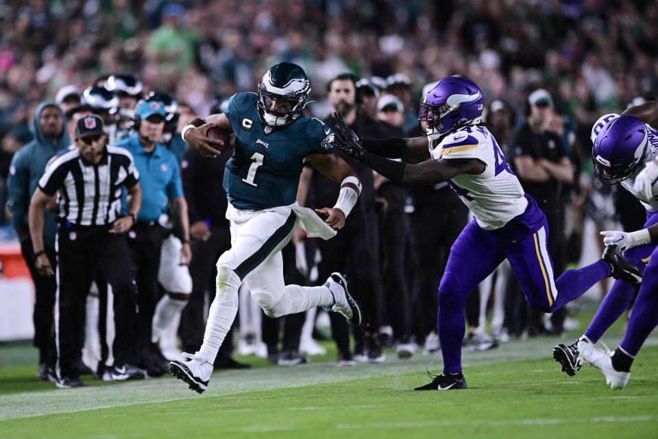 Philadelphia Eagles quarterback Jalen Hurts (1) runs with the ball in front of Minnesota Vikings safety Josh Metellus (44) during the first half of an NFL football game on Thursday, Sept. 14, 2023, in Philadelphia. (AP Photo/Derik Hamilton)