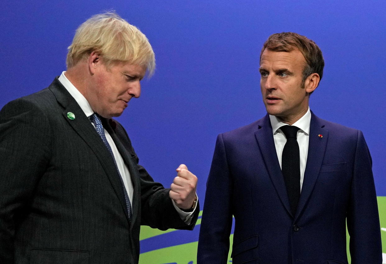 Britain's Prime Minister Boris Johnson greets France's President Emmanuel Macron during arrivals at the UN Climate Change Conference in Glasgow, Scotland, on Nov. 1, 2021. (Alastair Grant/Pool via Reuters)