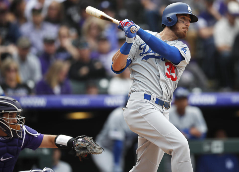 Los Angeles Dodgers' Cody Bellinger, right, follows the flight of his three-run home run off Colorado Rockies starting pitcher Tyler Anderson in the fifth inning of a baseball game Friday, April 5, 2019, in Denver. (AP Photo/David Zalubowski)