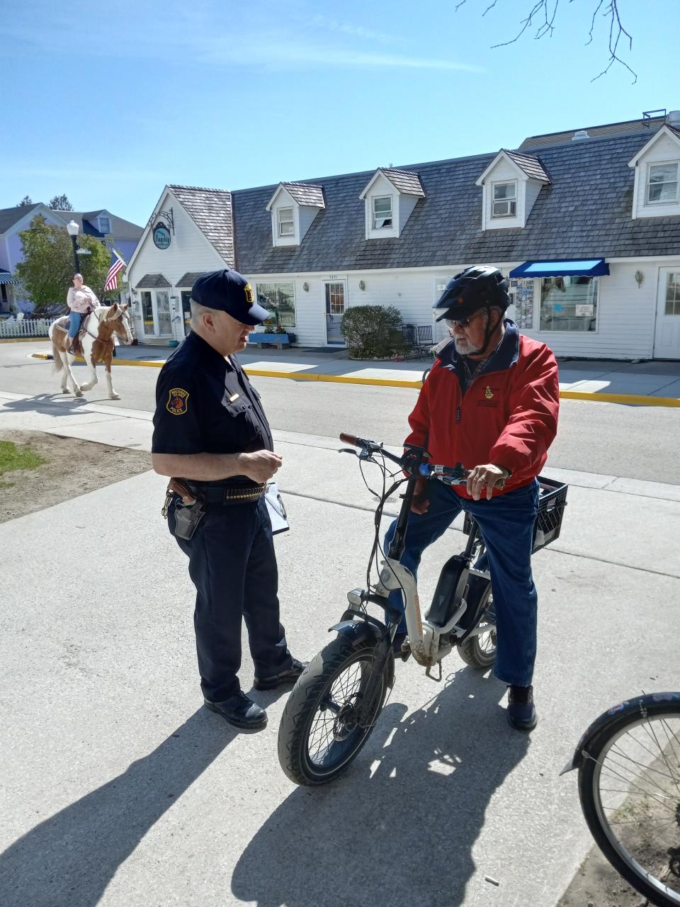 Mackinac Island Police Chief Doug Topolski talked Friday, May 26, 2023 to a bicyclist. Topolski explained to the cyclist that he needs to permanently remove the throttle on the e-bike and have it reclassified from Class II to Class I so that it's legal on the island. Only Class I e-bikes are allowed for residents and visitors with mobility disabilities. A Class I e-bike has a motor that provides pedal assistance only when the rider is pedaling and ceases to provide assistance at 20 mph. It has no throttle.