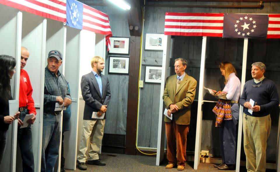 Voters cast their ballot shortly after midnight in New Hampshire, as the polls opened (Rex)