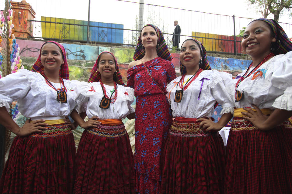 The California governor's wife, Jennifer Siebel Newsom poses for pictures accompanied by dance students dressed in the traditional costumes that the women of Panchimalco wore a century ago, in Panchimalco, El Salvador, Monday, April 8, 2019. (AP Photo/Salvador Melendez)