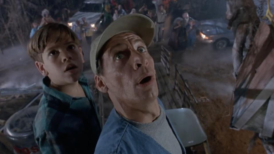 Ernest and Kenny look up scared from their treehouse as the town stands below them in Ernest Scared Stupid