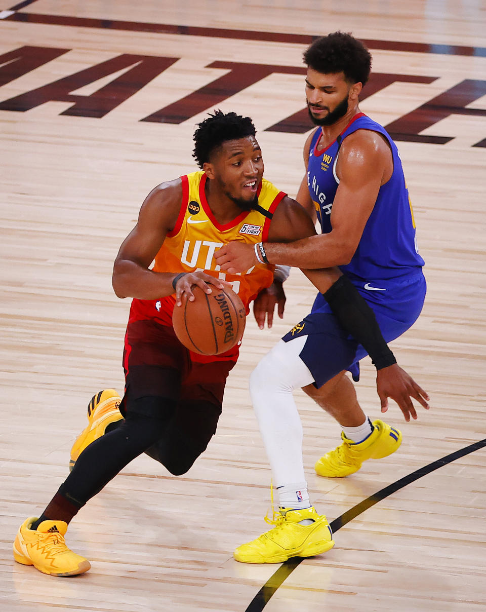 Utah Jazz's Donovan Mitchell, left, drives against Denver Nuggets' Jamal Murray, right, during the third quarter of an NBA basketball game Saturday, Aug. 8, 2020, in Lake Buena Vista, Fla. (Kevin C. Cox/Pool Photo via AP)