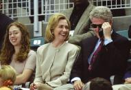 <p>During a break in the action, Bill Clinton tries on his sunglasses with Hillary and Chelsea at his side. (Getty) </p>