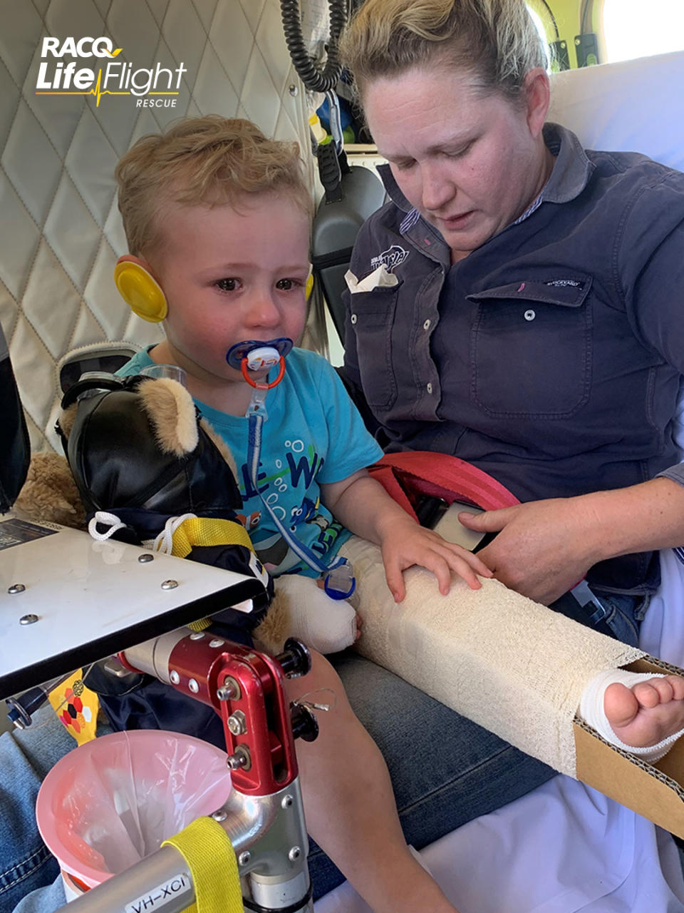 Photos show the boy’s mum holding him on her lap as the helicopter takes flight. Source: RACQ LifeFlight