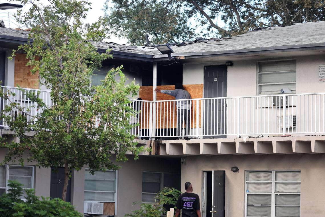 People boarding up doors and windows after a fire erupted at an apartment complex in Pompano Beach on Monday May 15, 2023. (Carline Jean/South Florida Sun Sentinel)